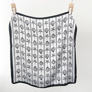 Detailed view of lightweight silk scarf featuring hand-drawn seashell and starfish patterns