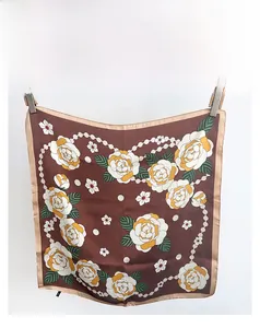 Détails de la texture du foulard en soie marron avec fleurs de camélia et motifs perles