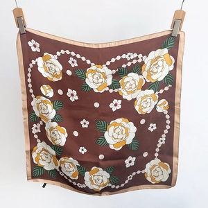 Détail d'un foulard en soie vintage avec d'élégantes roses blanches et motif de perles
