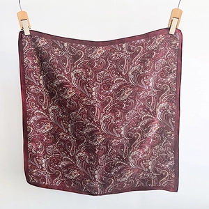 Detailed view of red paisley silk-like scarf showing fine vintage patterns and texture