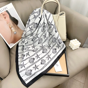 Elegant white square silk scarf with black border and marine ocean prints on bucket bag