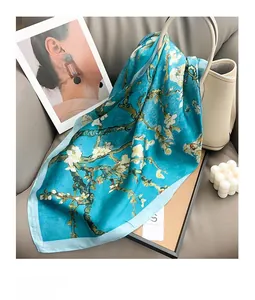 Detailed texture of silk scarf with blue almond blossom print on a leather bag