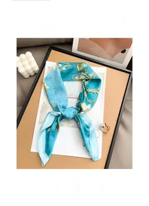 Detailed view of silk-like scarf with Van Gogh almond blossom print and pearl ring