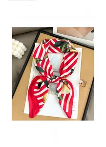 Détail d'un foulard en soie avec imprimé citron et rayures rouges, texture douce