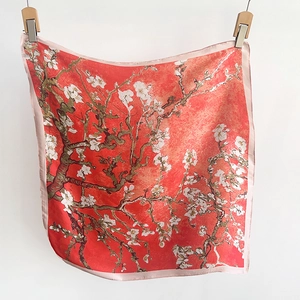 Detail view of red square silk scarf with white almond blossom print in Van Gogh art style