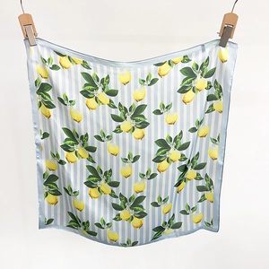 Détail d'un foulard en satin de soie avec imprimé citron et rayures bleues