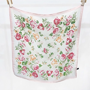 Dettaglio di foulard in seta con eleganti stampe di rose rosa e rosse su tessuto avorio