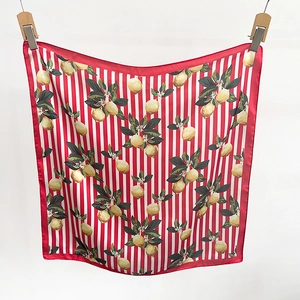 Détail d'un foulard en soie de style français avec imprimé citron et bord rayé rouge