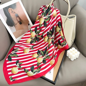 Foulard en soie style français avec motif citron et rayures rouges sur une chaise chic