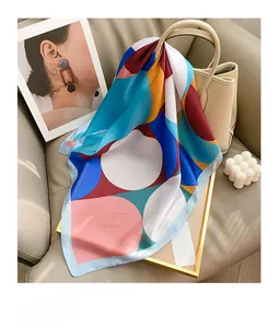 Detail of colorful geometric polka dot silk scarf draped on a beige leather handbag