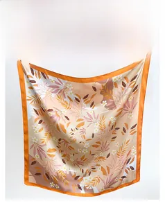 Détail du motif floral et de la bordure orange sur le foulard carré en aspect soie brillant