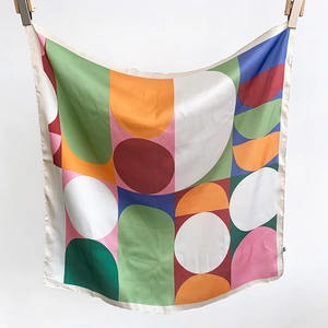 Detailed view of the vibrant geometric patterned satin scarf with fine hemmed edges