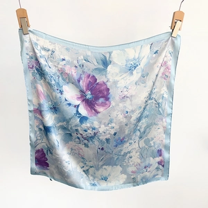 Macro view of floral silk scarf showing elegant lavender flower print and hemmed edges