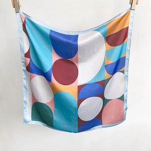 Detail view of square silk scarf showing geometric pattern and fine rolled hem edges