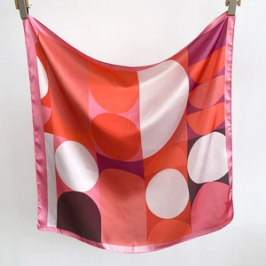 Vertical view of a satin square scarf featuring pink and orange geometric patterns