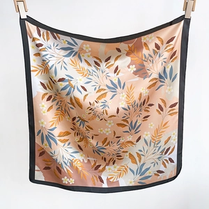 Détail du foulard en soie aux motifs floraux élégants avec bordure noire chic