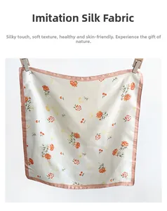 Detailed view of floral silk scarf featuring orange roses and pink satin stitched edges