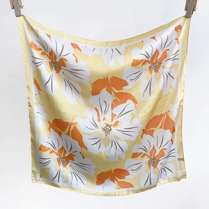 Close-up of lightweight floral silk scarf showing delicate yellow base and flower print