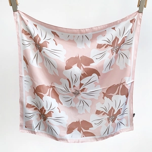 Detailed view of light pink floral silk scarf featuring large white and brown petal prints