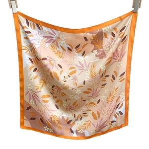 Carré en soie satinée avec bordure orange et motifs floraux de feuilles tropicales
