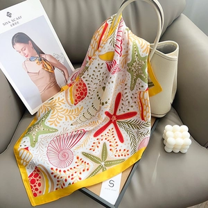 Élégant foulard en soie avec imprimé étoile de mer et coquillage sur un sac en cuir