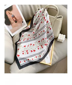 Detail of floral silk square scarf with vintage red patterns on a white background