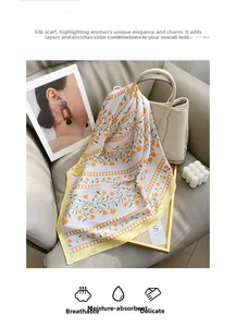 Close-up of lightweight silk scarf with orange floral print and pale yellow border detail