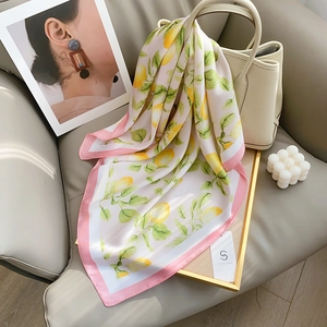 Carré en soie avec imprimé citron élégant sur un sac beige et accessoires modernes