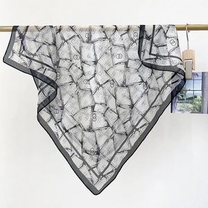 Detail of silk-like square scarf featuring black and white geometric prints and fine stitching