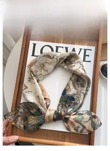 Detailed view of floral printed silk scarf with elegant deer and botanical patterns