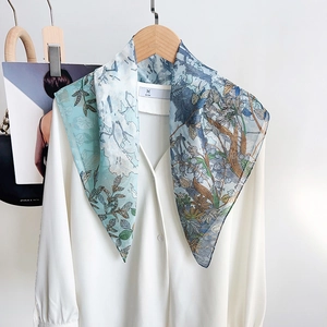 Detail of floral printed silk scarf paired with a white chiffon shirt for elegant styling
