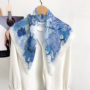 Élégant foulard en soie imprimé floral bleu et blanc porté avec une chemise blanche