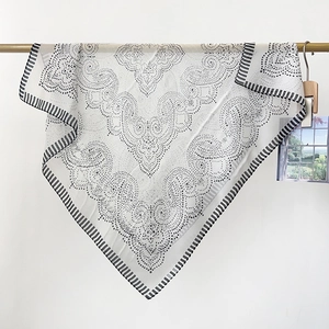 Close-up of lightweight chiffon scarf with black paisley polka dots and striped borders