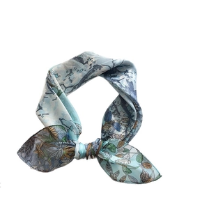 Elegant light blue floral silk scarf tied in a bow with delicate botanical patterns