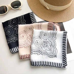 Three elegant polka dot scarves in black, beige, and white with chic striped borders