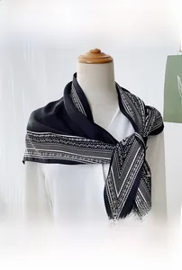Detail view of a black and white geometric pattern triangular scarf on a mannequin