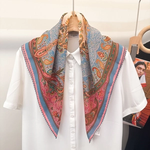 Detail eines bunten Seidenschals mit Paisleymuster kombiniert mit weißem Kurzarmhemd