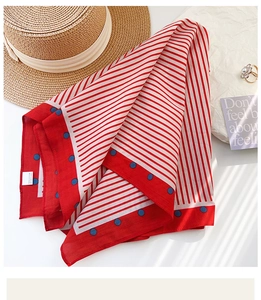 Detail of cotton neckerchief featuring blue polka dots and red stripe pattern textures
