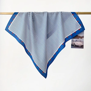 Detail of blue cotton square scarf with white stripes and red polka dots on metal bar