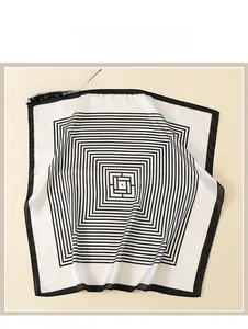 Détail d'un foulard en soie à rayures géométriques noires et blanches et logo labyrinthe