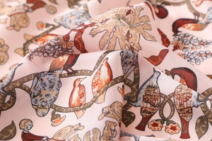 Close-up of pink silk satin scarf featuring vintage floral and bird prints with soft drape