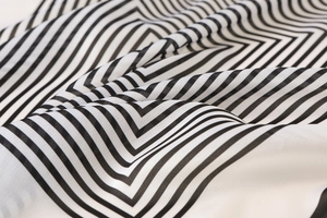 Gros plan d'un foulard en soie à rayures noires et blanches avec texture drapée lisse