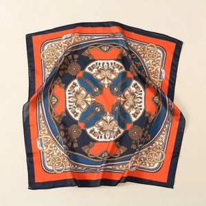 Detail of satin square scarf featuring vintage chain patterns and vibrant orange borders