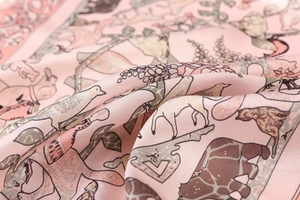 Detail of soft pink silk square scarf with animal prints and elegant satin texture
