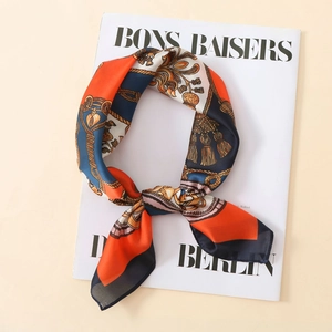 Elegant satin scarf with orange and navy chain print on fashion magazine background