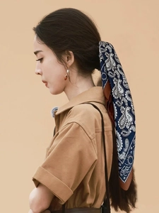 Detail of paisley print silk scarf used as a stylish hair tie for women ponytail accessory