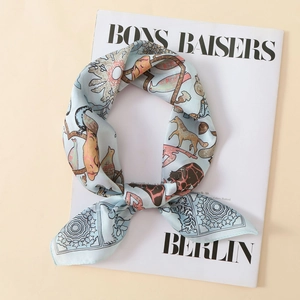Detailed close-up of light blue silk scarf with animal prints on fashion magazine