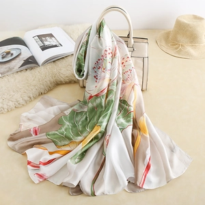 Détails de l'élégant foulard en soie à motif lotus drapé sur un sac à main chic
