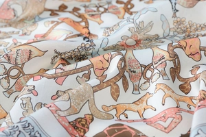 Detail shot of vintage animal print silk scarf featuring giraffes and warm floral patterns