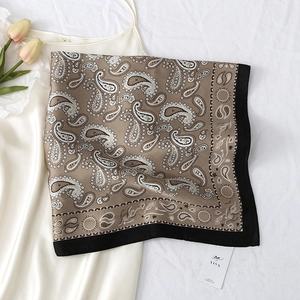 Close-up of silk-feel square scarf with paisley pattern and black contrast edges